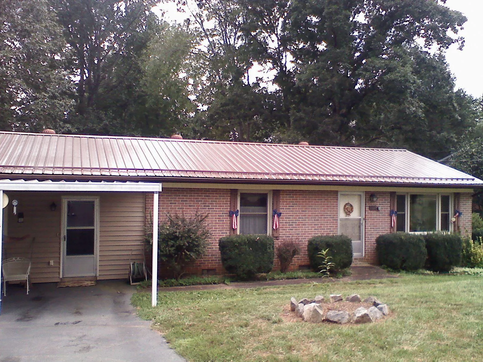 Bronze metal roof and carport on a brick ranch home — Roof Repair work by our crew in Spray